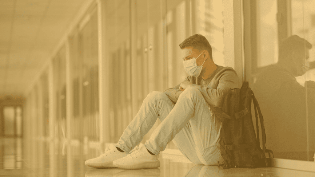 Man in a mask sitting in the hall of hospital